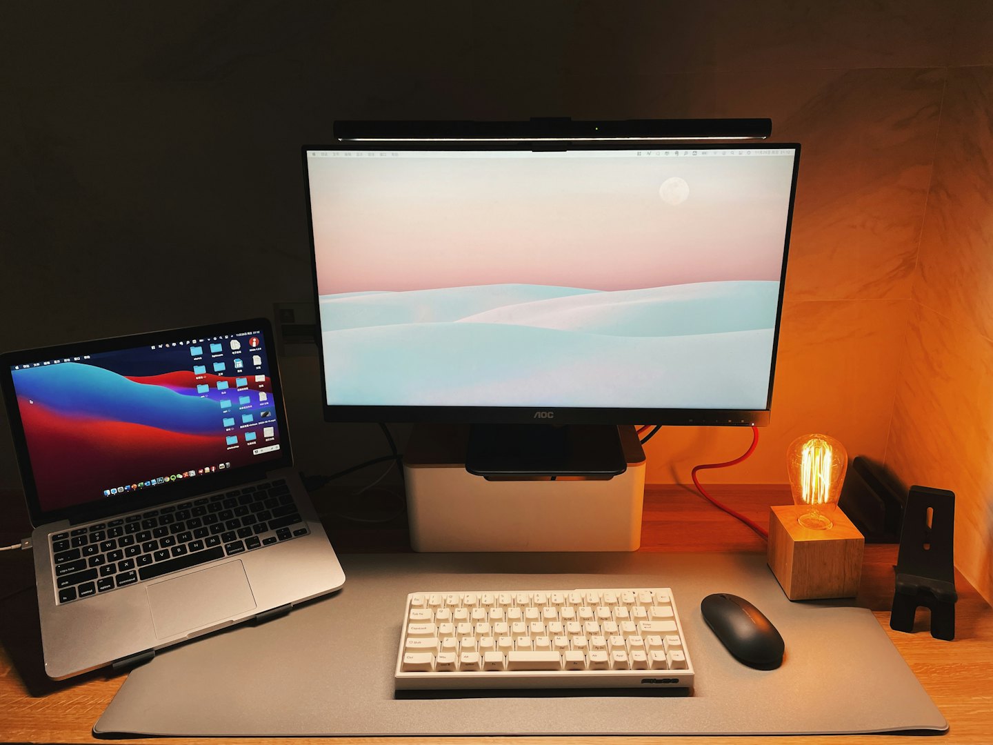 Un portátil y un monitor descansan sobre un escritorio de oficina de madera.